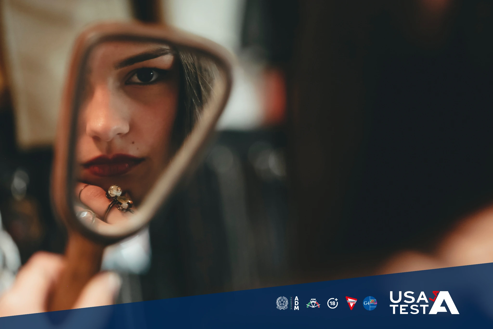 Persona che utilizza uno specchio come metafora di riflessione e come gesto simbolico di autoanalisi e consapevolezza legato al gioco responsabile, con loghi Usa la Testa.