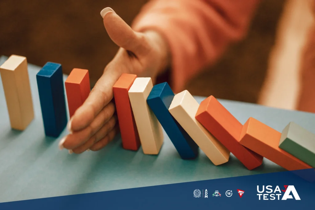 Mano che ferma una fila di tessere colorate come a interrompere un automatismo, simbolo di consapevolezza quando il gioco diventa abitudine.